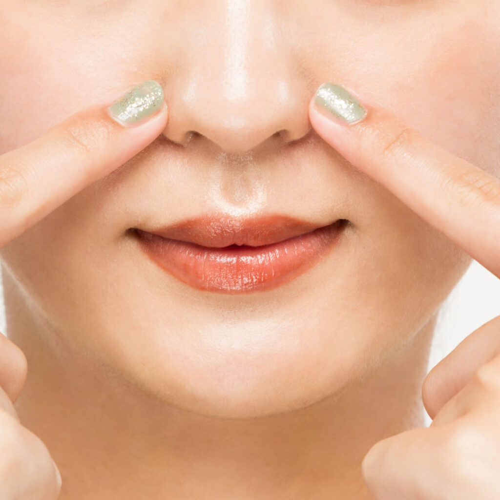 鼻のマッサージをしている女性