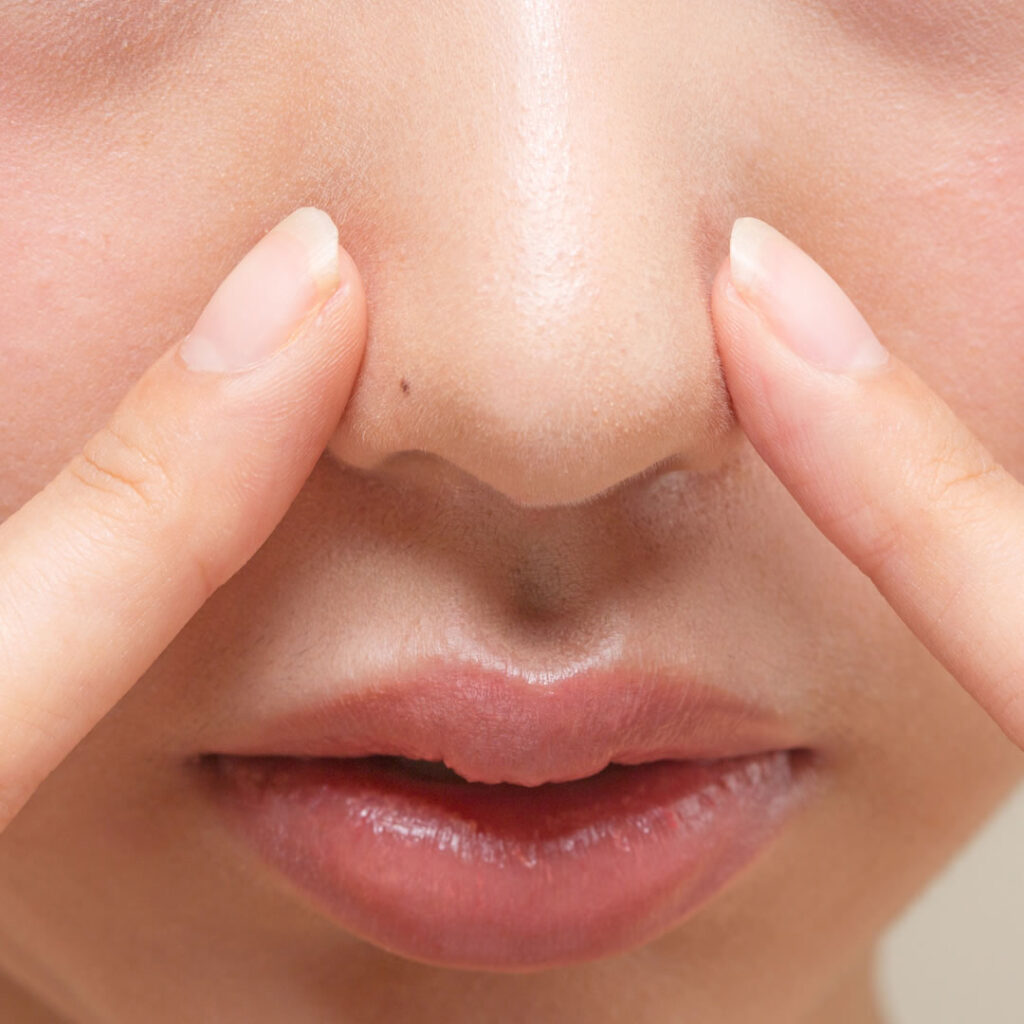 鼻の穴を小さくしようとしている女性